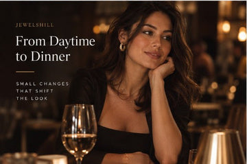 Woman in a black top seated at a restaurant table in evening light.